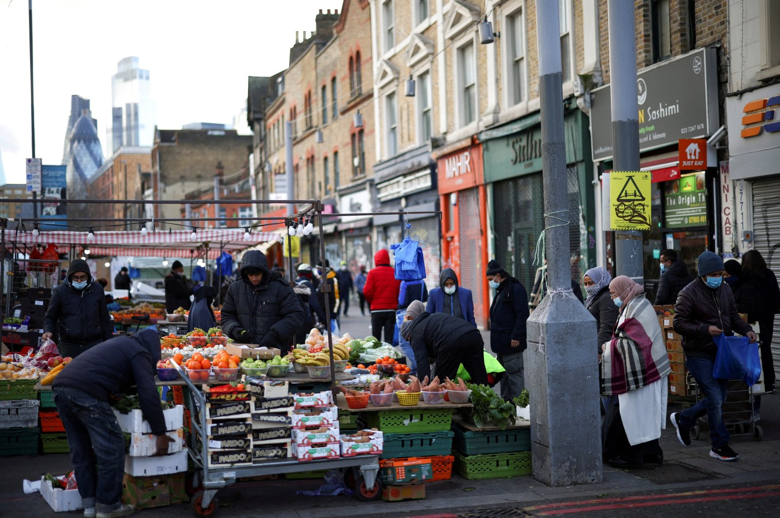 People shop at a market stalls in east London, Britain, Jan. 23, 2021. (Reuters Photo)