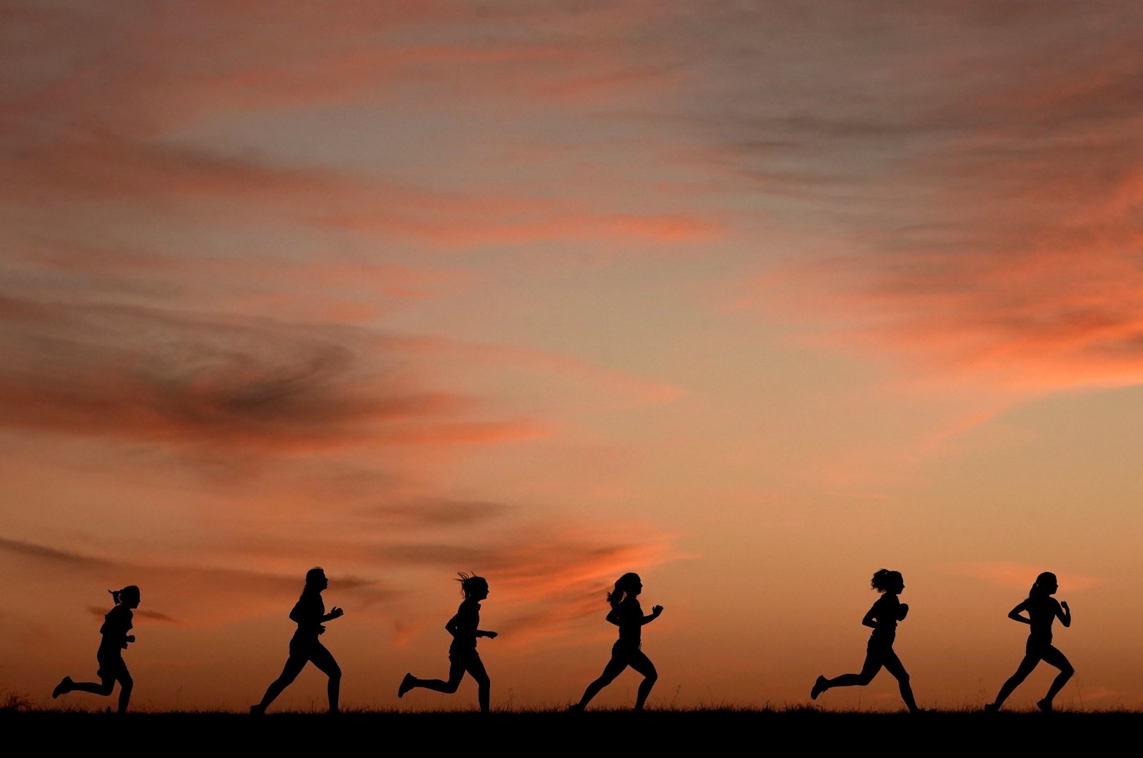 High school students run at sunset as they practice for the track and field season, Shawnee, Kansas, U.S., Feb. 28, 2022. (AP File Photo)
