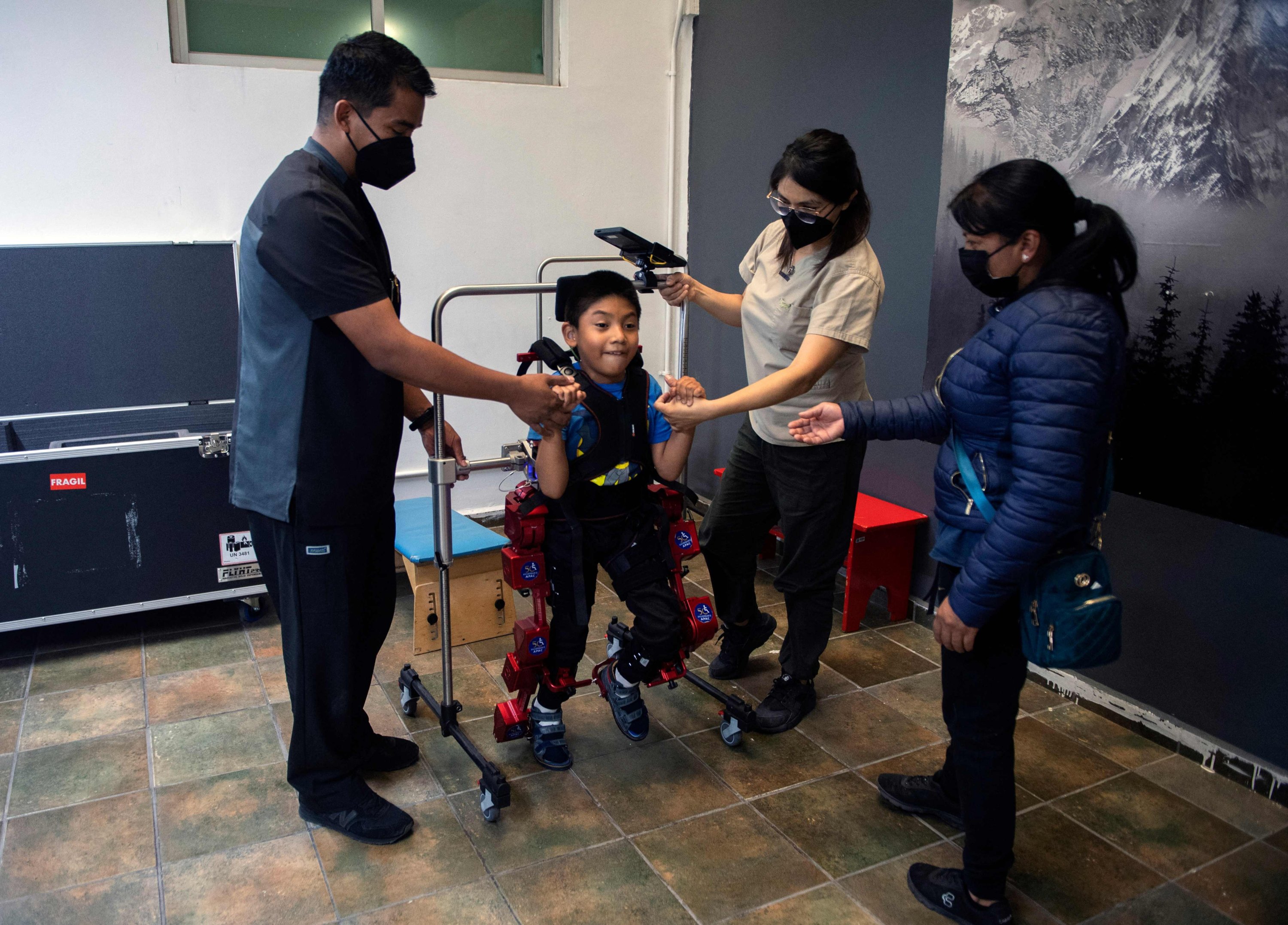 David Zabala dibantu oleh ahli terapi fisik dan ibunya, selama sesi rehabilitasi, di Association for People with Cerebral Palsy di Mexico City, Meksiko, 18 Oktober 2022. (AFP Photo)