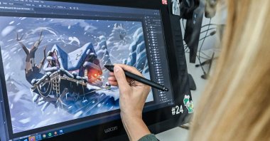 A woman works on a pen display at the &quot;Mario   The Lapins Crétins: Sparks of Hope&quot; game at the Ubisoft headquarter in Milan, Italy, Oct. 7, 2022. (AFP Photo)