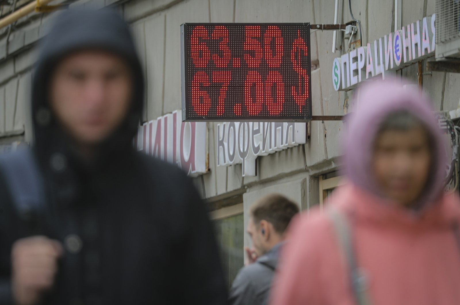 People walk in front of a currencies exchange office with the U.S. dollar exchange rates shown in the background in Moscow, Russia, Sept. 23, 2022. (EPA Photo)