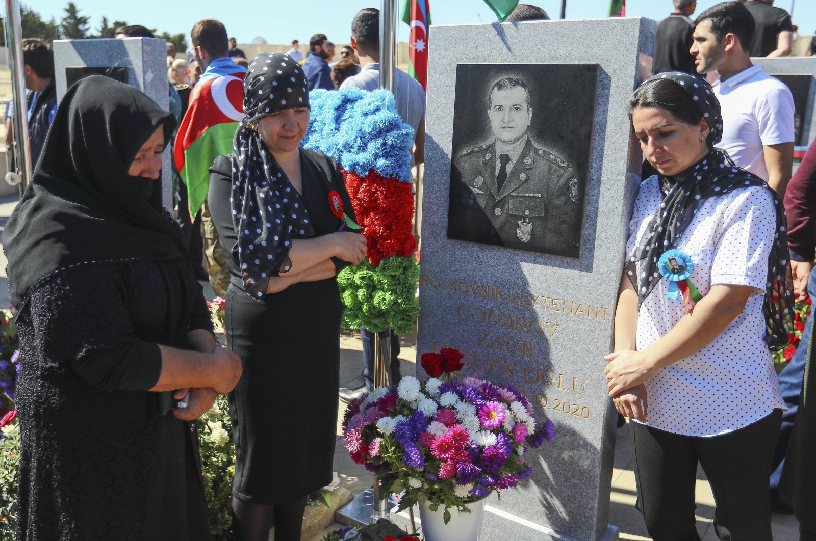Relatives mourn near the grave of an Azerbaijani soldier at a military cemetery housing the graves of soldiers who died during the Second Karabakh War, outside Baku, Azerbaijan, Sept. 27, 2021. (AP Photo)