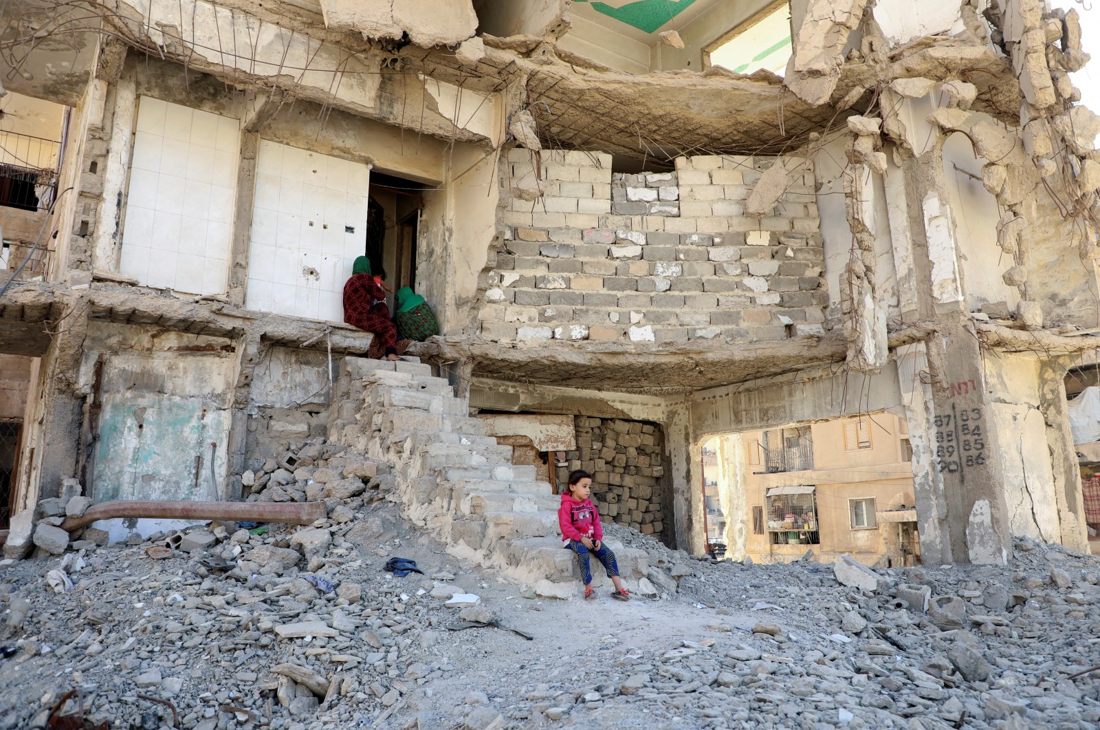 People sit in a damaged building in Raqqa, Syria, Oct.12, 2022. (Reuters Photo)