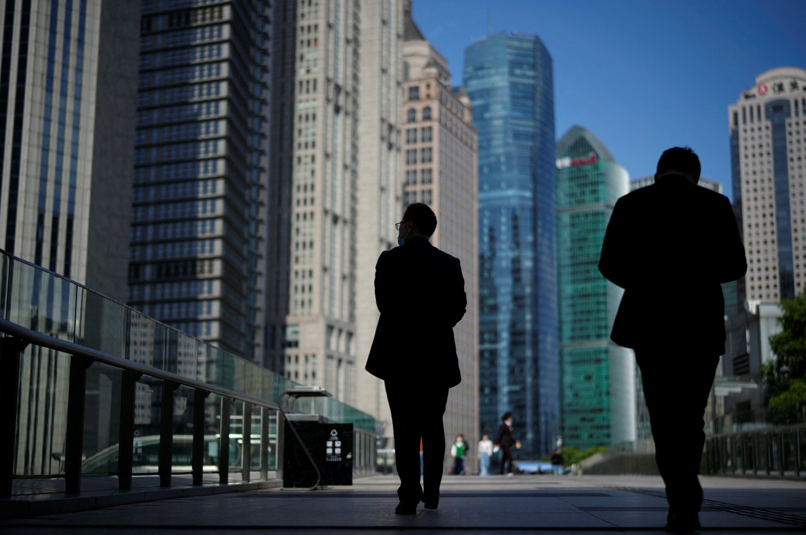 People walk by office towers in the Lujiazui financial district of Shanghai, China, Oct. 17, 2022. (Reuters Photo)