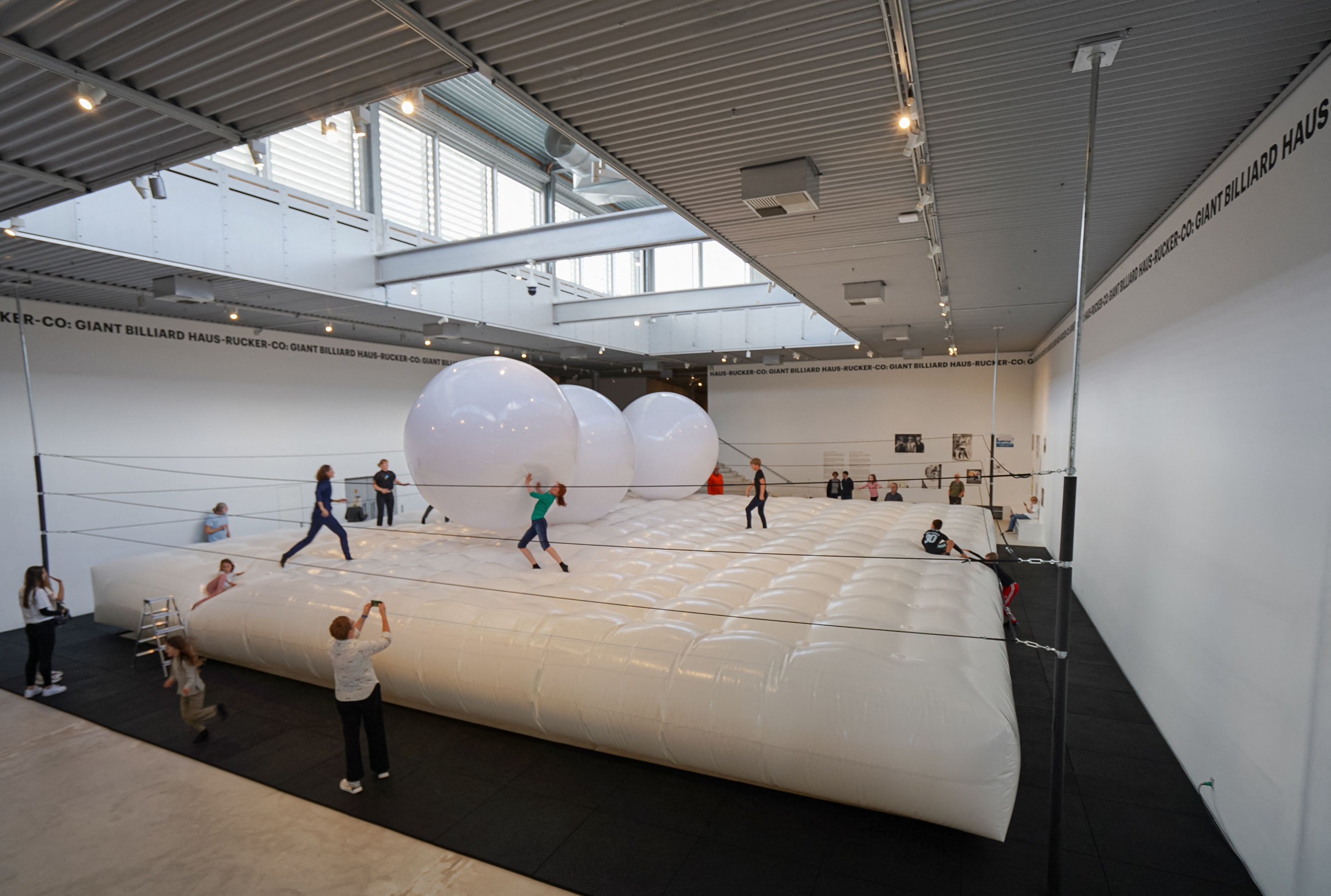 Pengunjung berinteraksi dengan 'Giant Billiard', sebuah instalasi seni oleh arsitek/kelompok seniman Austria Haus-Rucker-Co, awalnya dipentaskan pada tahun 1970 dan dibuat ulang di Arken Museum of Modern Art di Ishoj, dekat Kopenhagen, Denmark, 8 Oktober 2022. (Foto AFP)