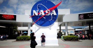 Tourists take pictures of a NASA sign at the Kennedy Space Center visitors complex in Cape Canaveral, Florida, U.S., April 14, 2010. (Reuters Photo)