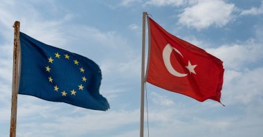 Tattered Turkish and European Flags flying on the beach in Alanya on the Mediterranean Coast, Türkiye. (Shutterstock Photo)