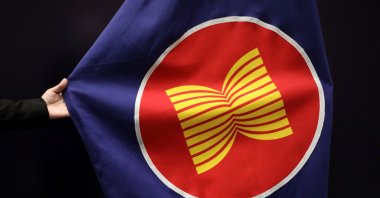 A worker adjusts an ASEAN flag at a meeting hall in Kuala Lumpur, Malaysia, Oct. 28, 2021. (REUTERS Photo)