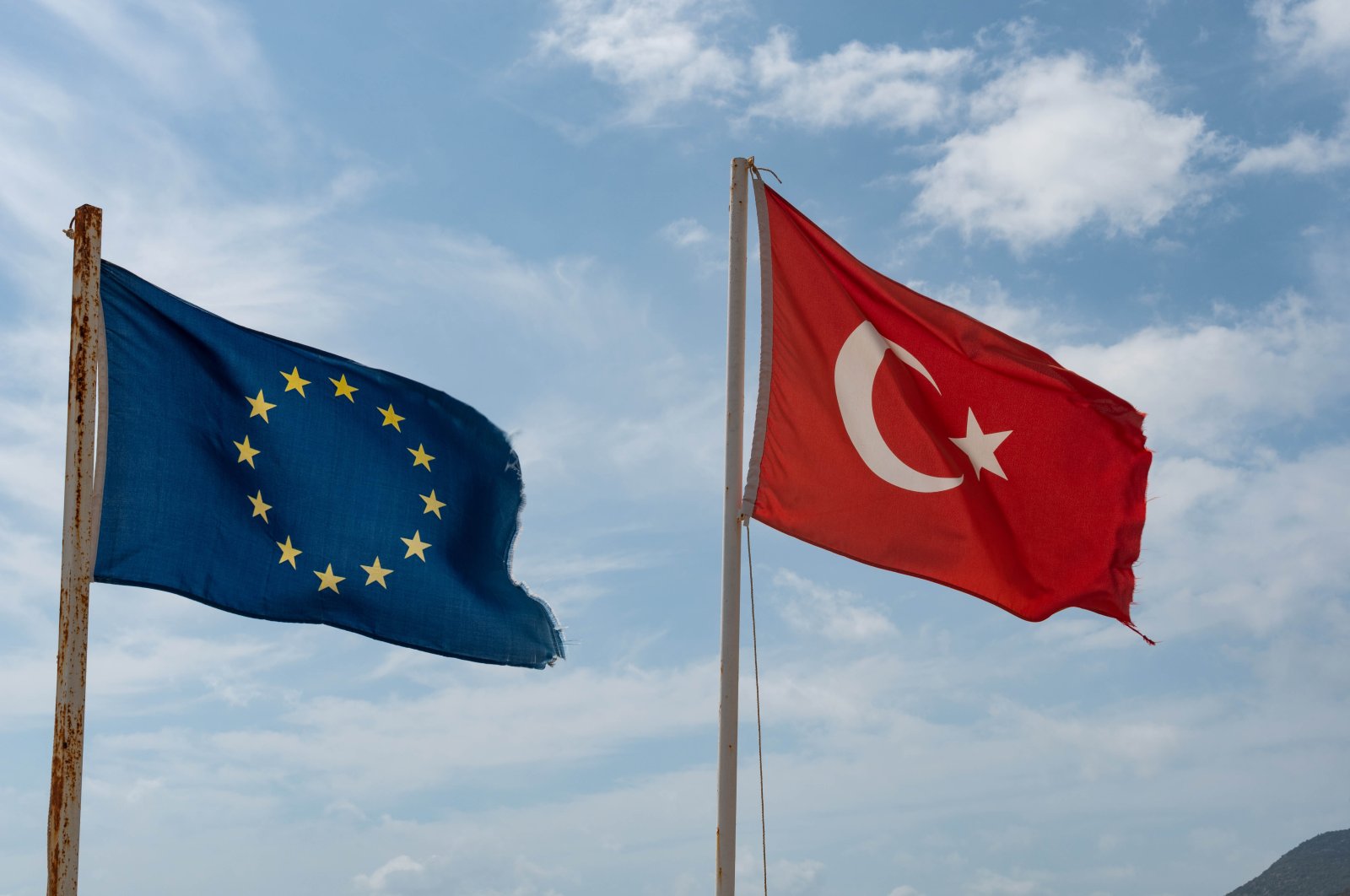 Tattered Turkish and European Flags flying on the beach in Alanya on the Mediterranean Coast, Türkiye. (Shutterstock Photo)