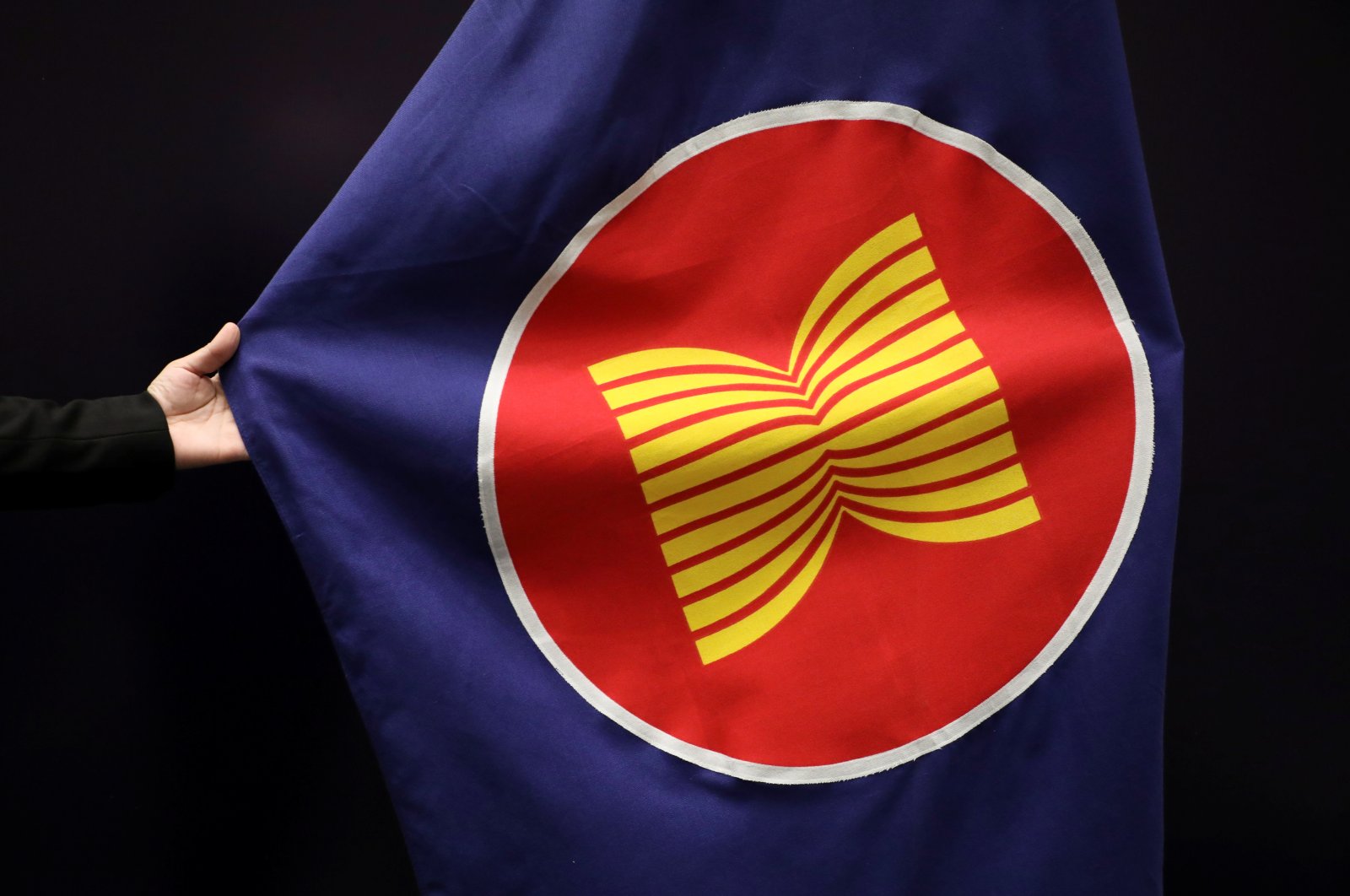 A worker adjusts an ASEAN flag at a meeting hall in Kuala Lumpur, Malaysia, Oct. 28, 2021. (REUTERS Photo)
