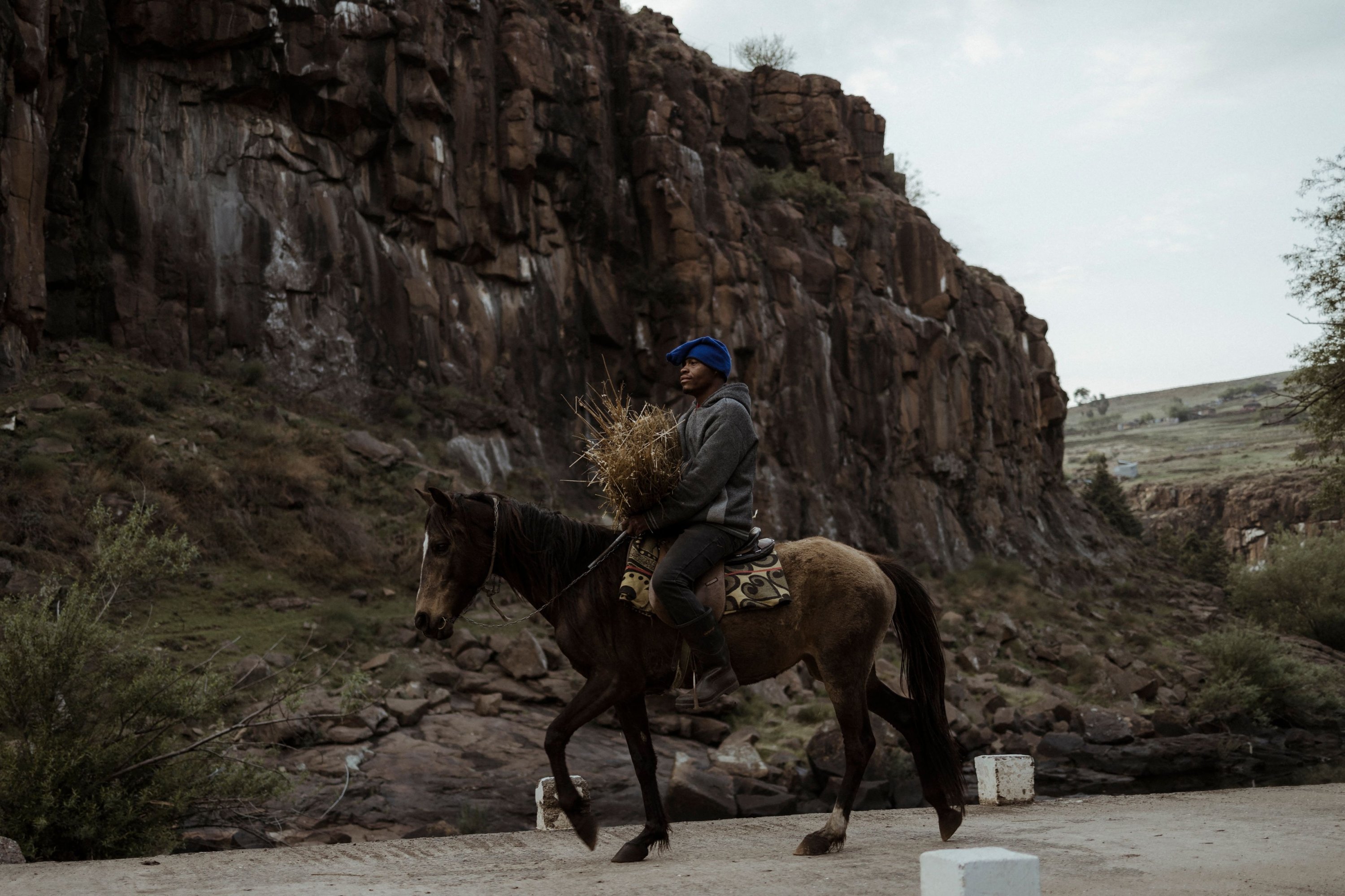 Seorang penunggang kuda Lesotho mengendarai kuda poni Basotho saat melintasi jembatan di atas sungai Maletsunyane di Semonkong, Lesotho, 15 Oktober 2022. (AFP Photo)