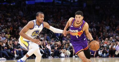 Phoenix Suns&#039; Devin Booker #1 drives the ball past Moses Moody #4 of the Golden State Warriors during the second half of the NBA game at Footprint Center, Phoenix, Arizona, Oct. 25, 2022. (AFP Photo)