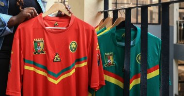 A shopkeeper holds a Cameroonian football shirt on sale at the Central market in Yaounde, Cameroon, Sept. 23, 2022. (AFP Photo)