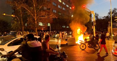 A police motorcycle burns during a protest over the death of Mahsa Amini, a woman who died after being arrested by the Islamic Republic's "morality police," in Tehran, Iran, Sept. 19, 2022. (Reuters File Photo)