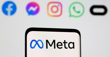 The Meta logo is seen on a smartphone in front of the displayed logos of Facebook, Messenger, Instagram, WhatsApp and Oculus in this illustration picture taken on Oct. 28, 2021. (Reuters File Photo)