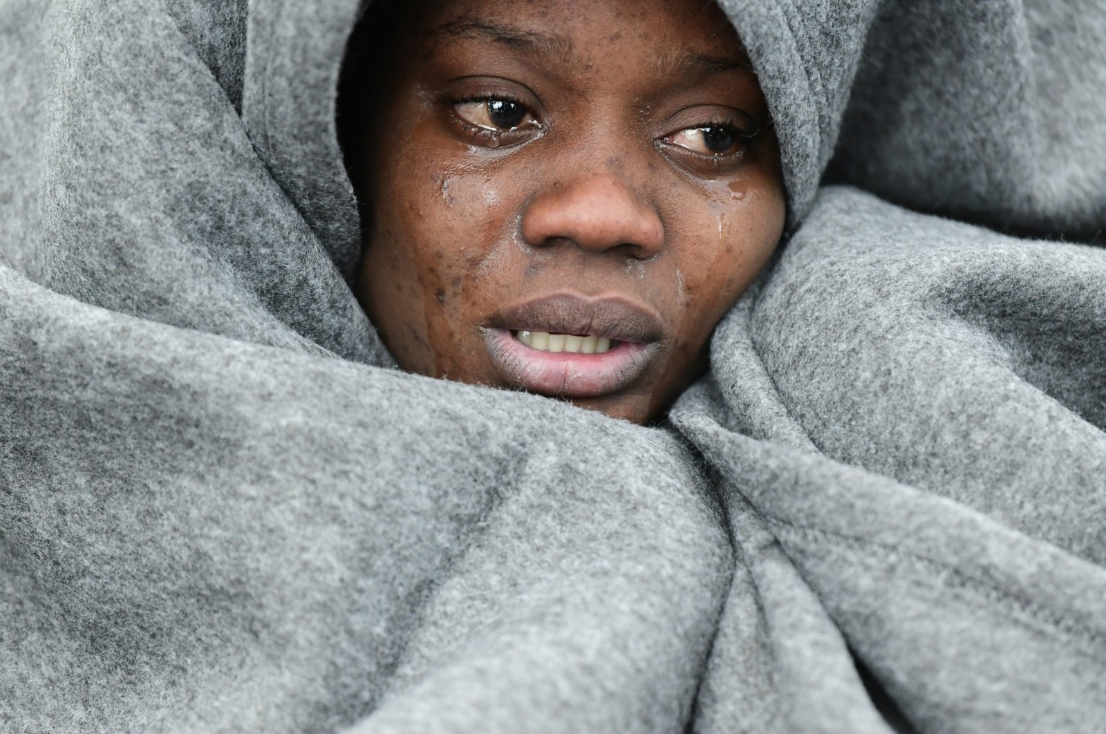 A migrant cries as she tries to warm herself as she and others arrive at the village of Skala Sikaminias, on the Greek island of Lesbos, after crossing the Aegean Sea, Feb. 29, 2020. (AP Photo)