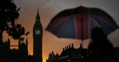 A woman walks past Big Ben as she waits in line to pay respect to the late Queen Elizabeth II at Westminster Hall in London, England, Sept. 18, 2022. (AP Photo)