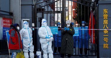 Security personnel in protective suits stand at the gate of a residential compound under COVID-19 lockdown, Beijing, China, Oct. 22, 2022. (Reuters Photo)