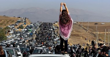 A woman stands on top of a vehicle as thousands make their way toward Mahsa Amini&#039;s grave in Saqez, Iran, Oct. 26, 2022. (AFP Photo)