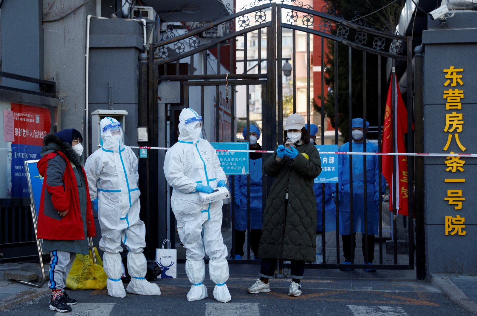 Security personnel in protective suits stand at the gate of a residential compound under COVID-19 lockdown, Beijing, China, Oct. 22, 2022. (Reuters Photo)