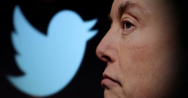 The Twitter logo and a photo of Elon Musk are displayed through a magnifier in this illustration taken Oct. 27, 2022. (Reuters Photo)