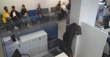 Security camera footage shows the thief stealing money from the bank in Şişli, Istanbul, Oct. 26, 2022. (DHA Photo)