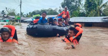 Rescue workers evacuating people from a flooded area due to heavy rain brought by Tropical Storm Nalgae, Parang, Maguindanao province, Philippines, Oct. 28, 2022. (AFP Photo)