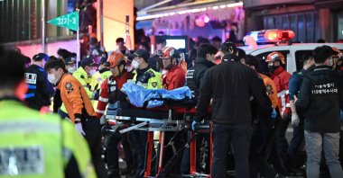 A person, believed to have suffered from cardiac arrest, is transported on a stretcher in the popular nightlife district of Itaewon in Seoul, South Korea, Oct. 30, 2022. (AFP Photo)