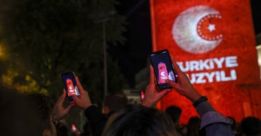 People take photos of a visual presentation reflected on Galata Tower on the occasion of Republic Day celebrations, Istanbul, Türkiye, Oct. 29, 2022. (AA Photo)