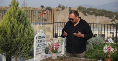 Uğur Gezgin, the father of Little Ayda, the symbol of hope and unity of the İzmir earthquake, prays at her wife's grave in a cemetery in İzmir, western Türkiye, Oct. 27, 2022. (AA Photo)