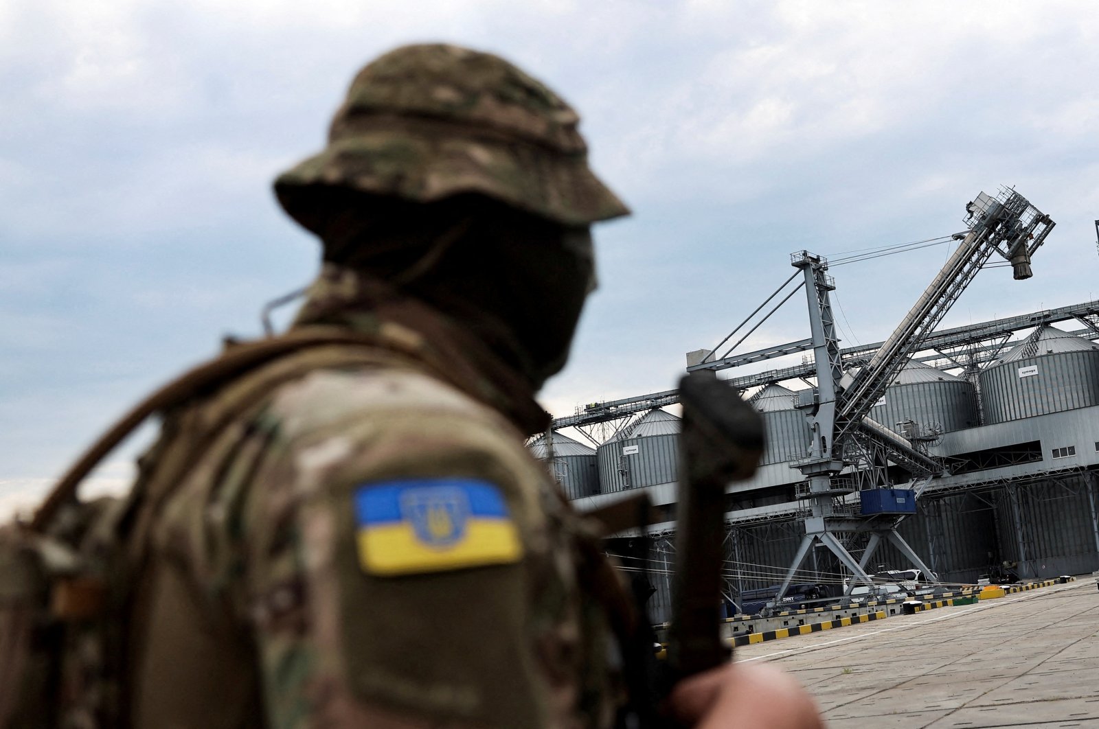 A Ukrainian soldiers stands in front of silos of grain at Odessa&#039;s Black Sea port, before the shipment of grain, Odessa, Ukraine, July 29, 2022. (Reuters Photo)
