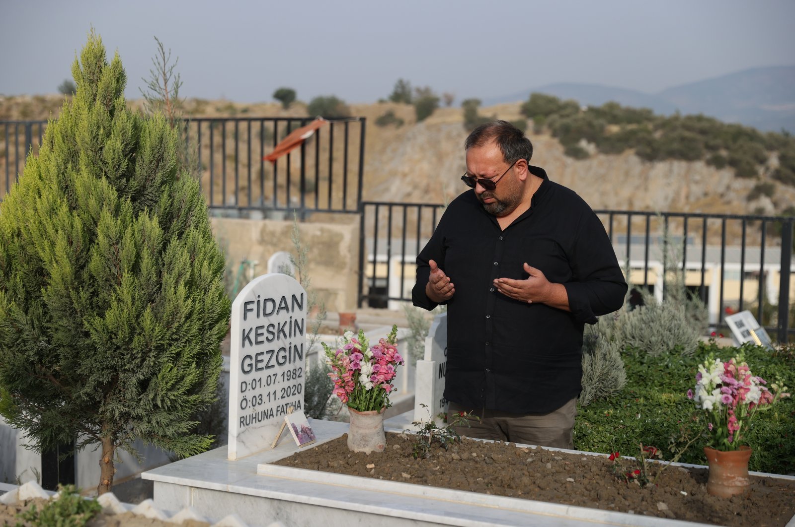 Uğur Gezgin, the father of Little Ayda, the symbol of hope and unity of the İzmir earthquake, prays at her wife&#039;s grave in a cemetery in İzmir, western Türkiye, Oct. 27, 2022. (AA Photo)