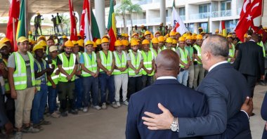 Benin's Foreign Minister Aurelien Agbenonci (L) and Foreign Minister Mevlüt Çavuşoğlu (R) visit construction workers in Kotonu, Benin, Oct. 27, 2022. (AA Photo)