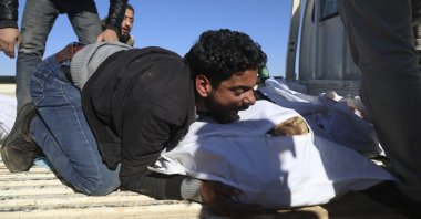 A man mourns over the bodies during the funeral of six family members filed in shelling in the Maaret al-Naasan village in Idlib province, Syria, Feb. 12, 2022. (AP Photo)