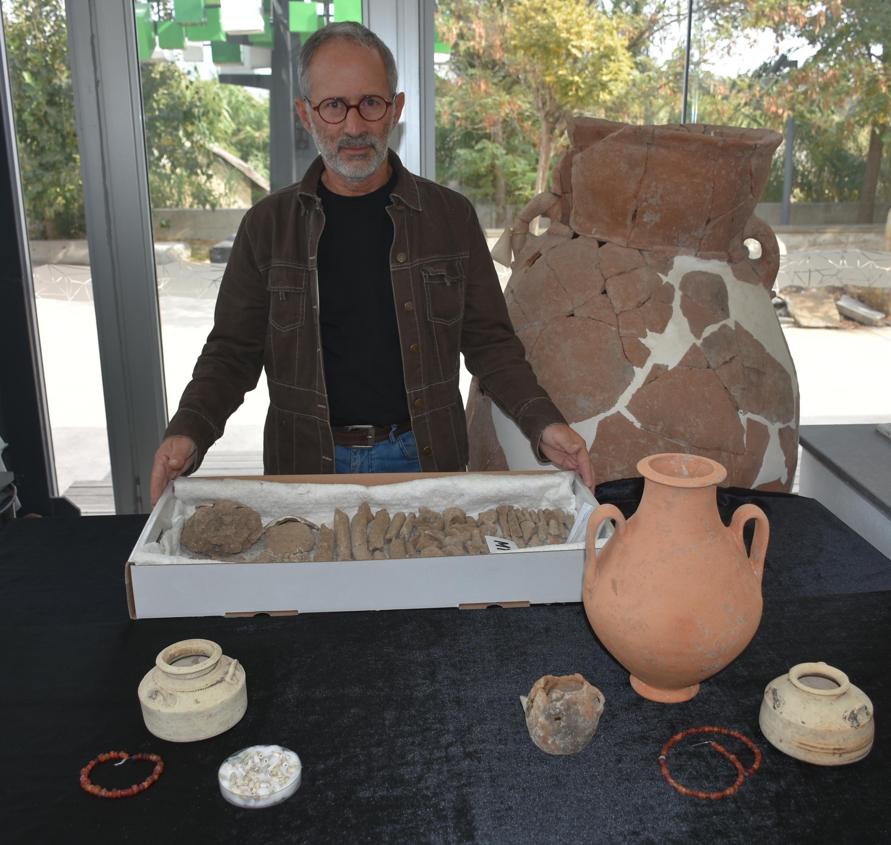 Excavation director Zafer Derin displays the artifacts and bones unearthed during the excavations in Yeşilova tumulus, Izmir, Türkiye, Oct. 30, 2022. (DHA Photo)