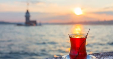 A cup of Turkish tea against the Maiden Tower, in Istanbul, Türkiye. (Shutterstock Photo)