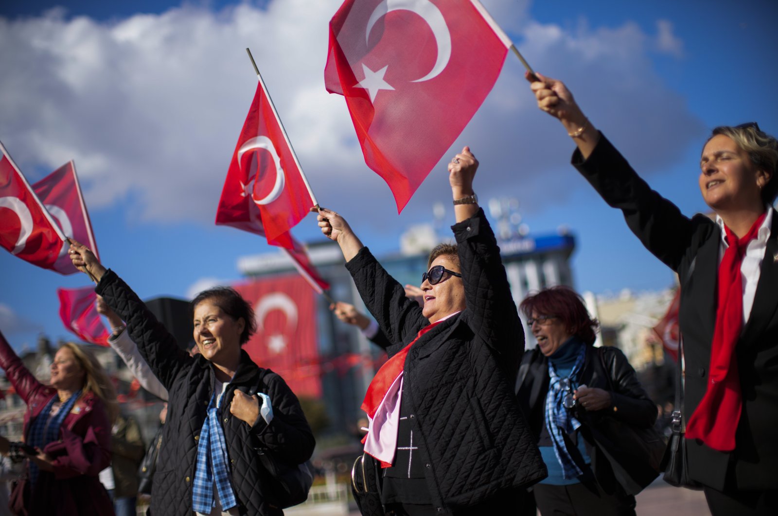People wave Turkish flags as they listen to a military music band performing at Taksim square in Istanbul, Türkiye, Oct. 28, 2022. (AP Photo)