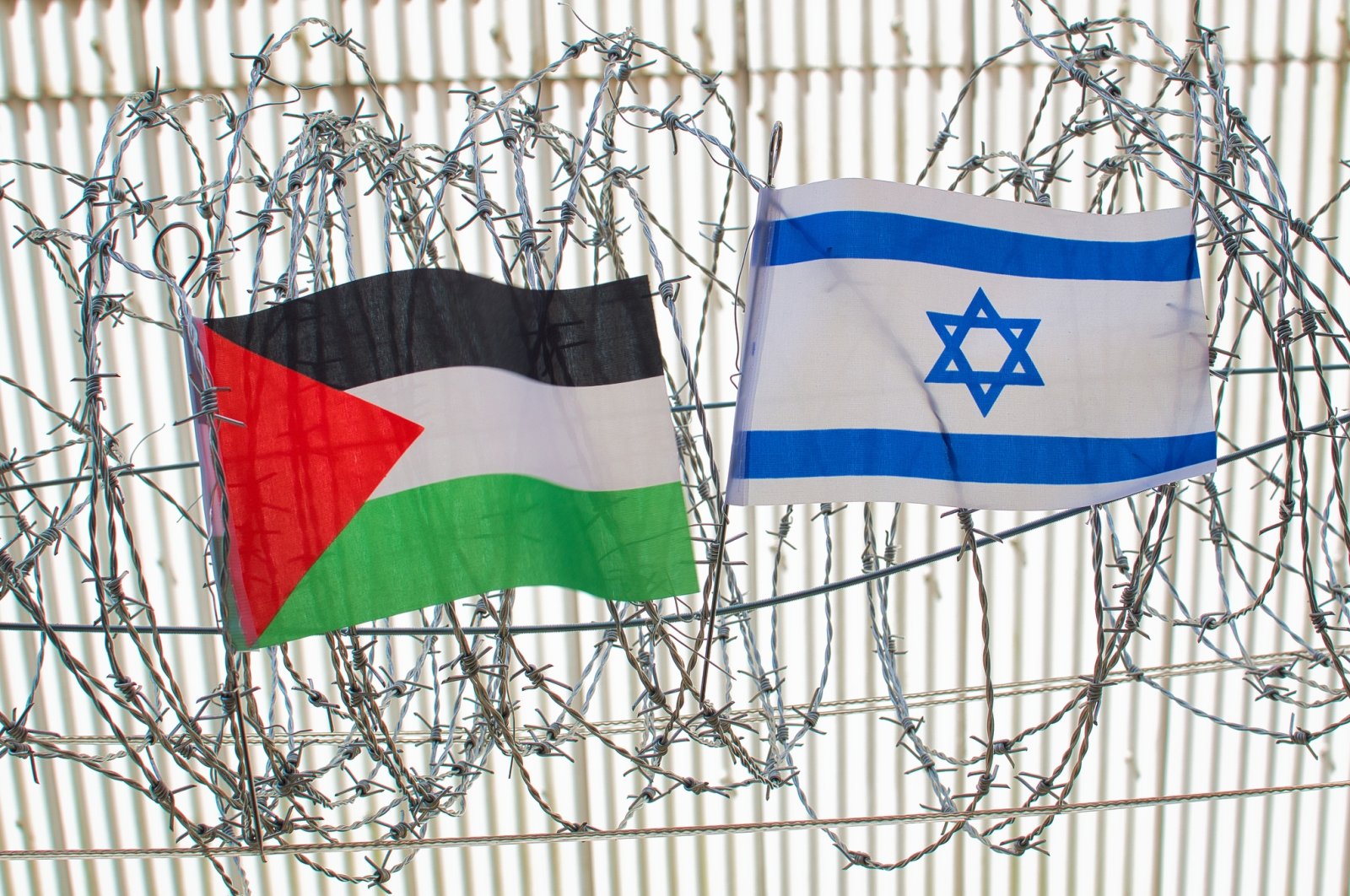 Illustration shows Palestine and Israel flags on barbed wire. (Getty Images Photo)