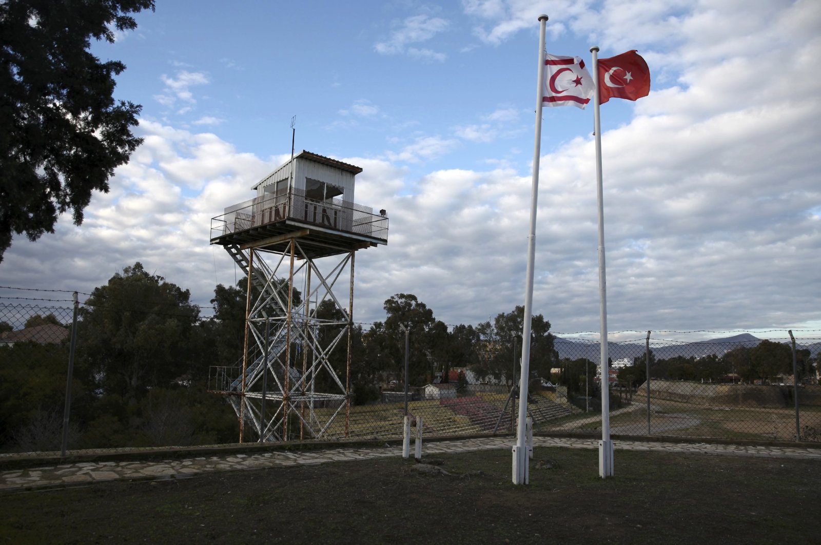 A U.N. guard post is seen on the buffer zone as a Turkish and a Turkish Cypriot flag wave in the capital Lefkoşa (Nicosia), TRNC, Jan. 12, 2017. (Reuters Photo)