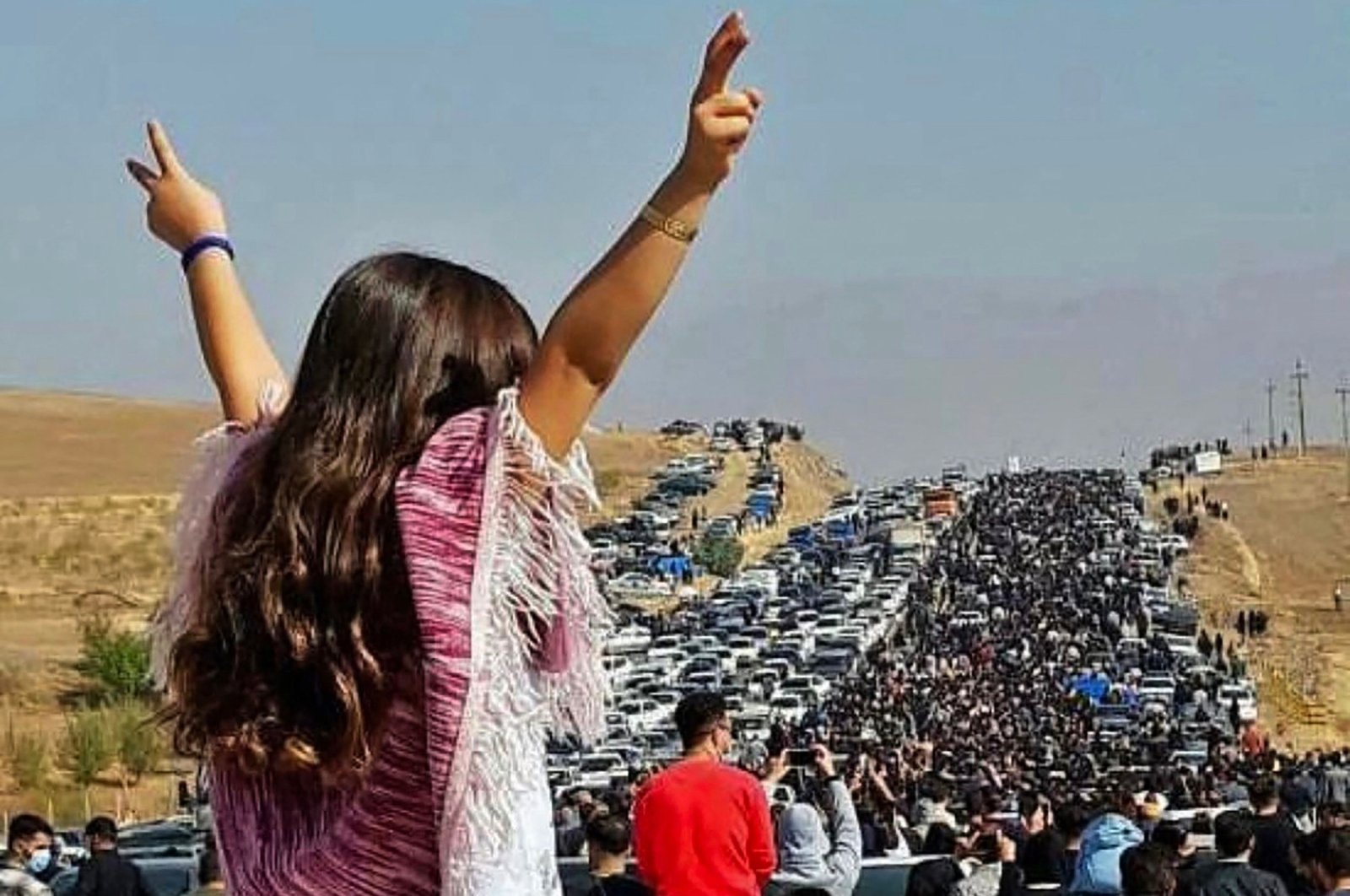 A woman stands on top of a vehicle as thousands make their way toward Mahsa Amini&#039;s grave, Saqez, Iran, Oct. 26, 2022. (AFP Photo)