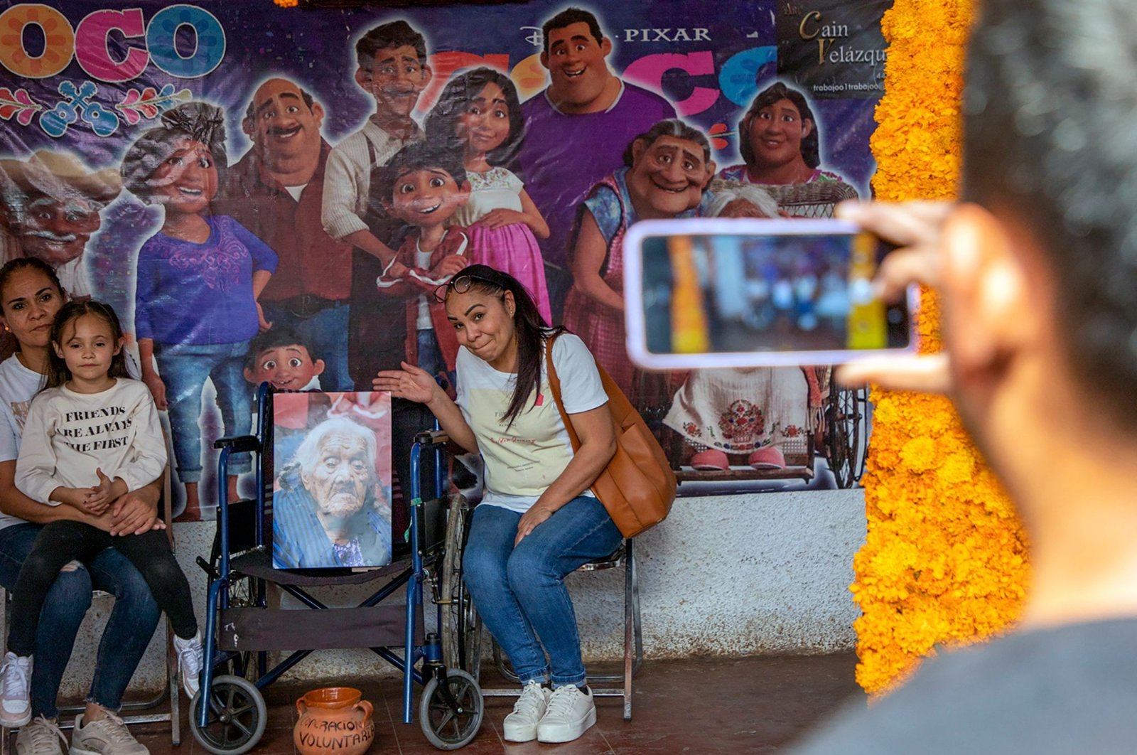 Tourists poses for a picture at the house of Maria Salud Ramirez Caballero, known as Mama Coco, in Santa Fe de la Laguna, Michoacan state, Mexico, Oct. 30, 2022. (AFP Photo)