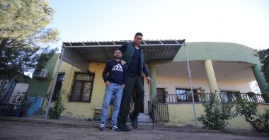 Sultan Kösen (R) walks outside his home, in Mardin, southeastern Türkiye, Nov. 4, 2022. (AA Photo) 