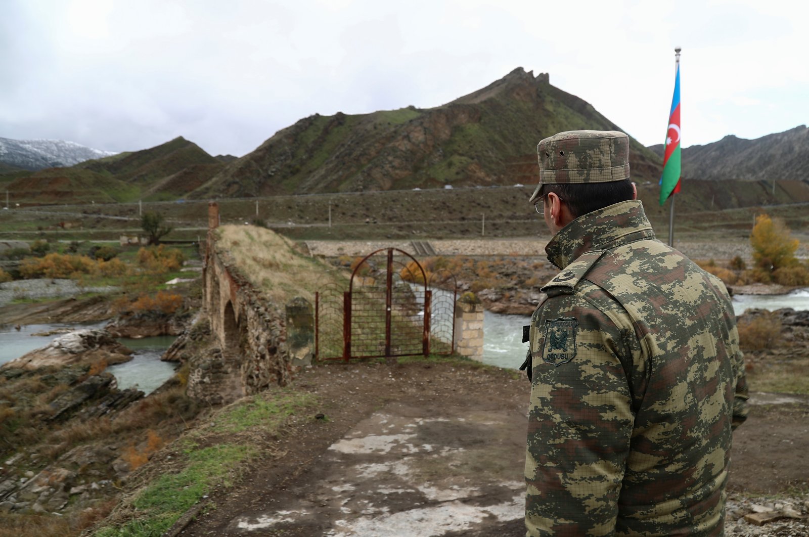 An Azerbaijani service member looks at the ancient Khodaafarin Bridge near the border with Iran in the area in Jabrayil District, Karabakh, Azerbaijan December 7, 2020. (REUTERS Photo)