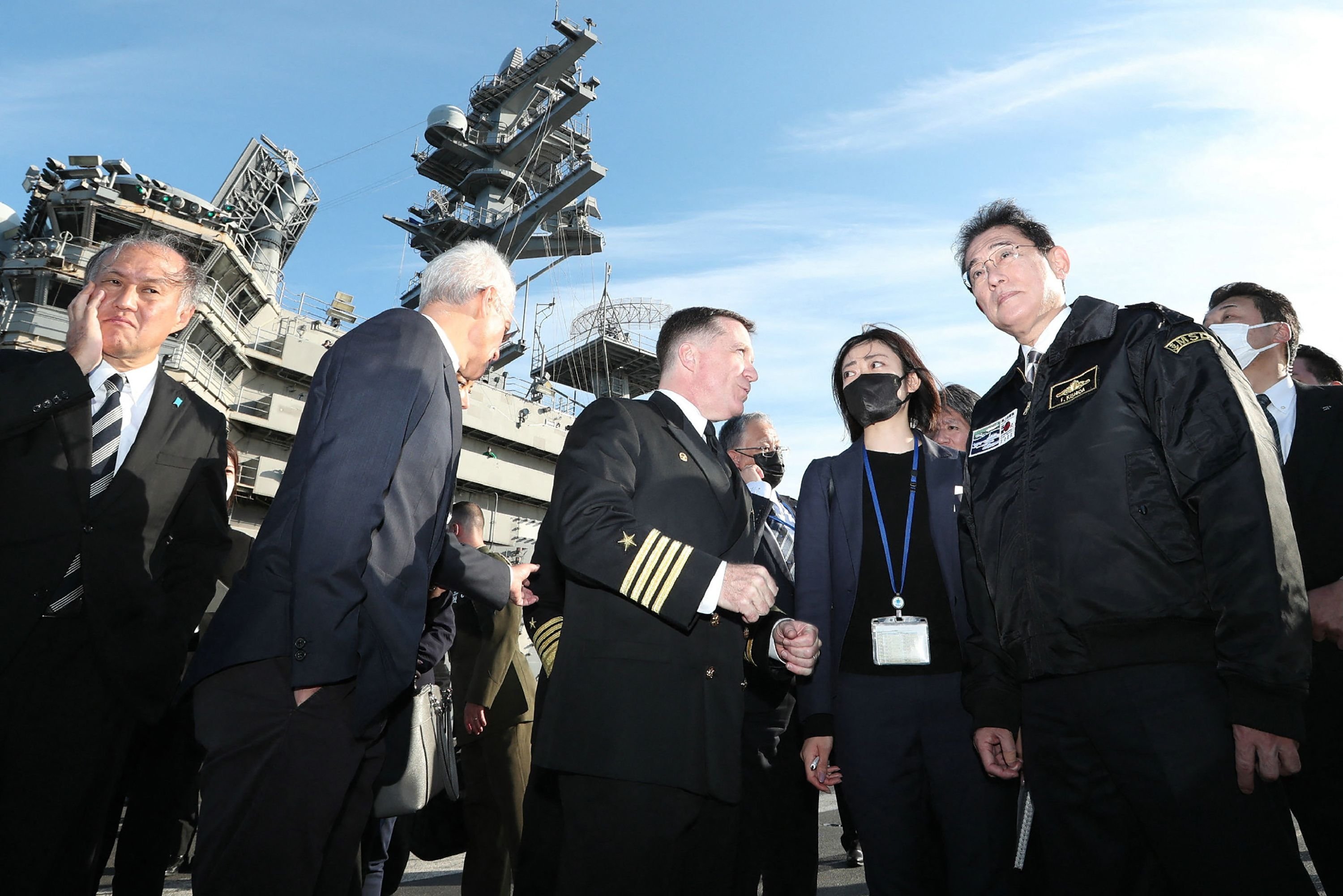 Perdana Menteri Jepang Fumio Kishida (kanan) mendengarkan seorang pejabat di atas kapal induk AS USS Ronald Reagan, Teluk Sagami, Jepang, 6 November 2022. (AFP Photo)
