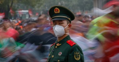 A soldier stands guard as runners compete during the Beijing Marathon in Beijing, China, Nov. 6, 2022. (EPA Photo)