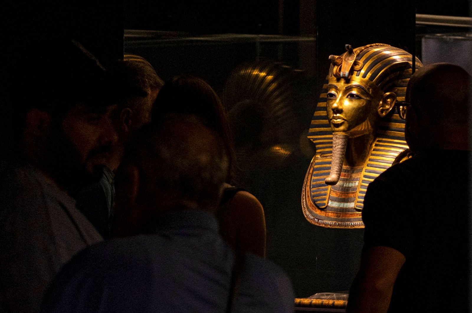 Visitors view the gold burial mask of the ancient Egyptian New Kingdom Pharaoh Tutankhamun on display at the Egyptian Museum, Cairo, Egypt, Oct. 19, 2022. (AFP Photo)