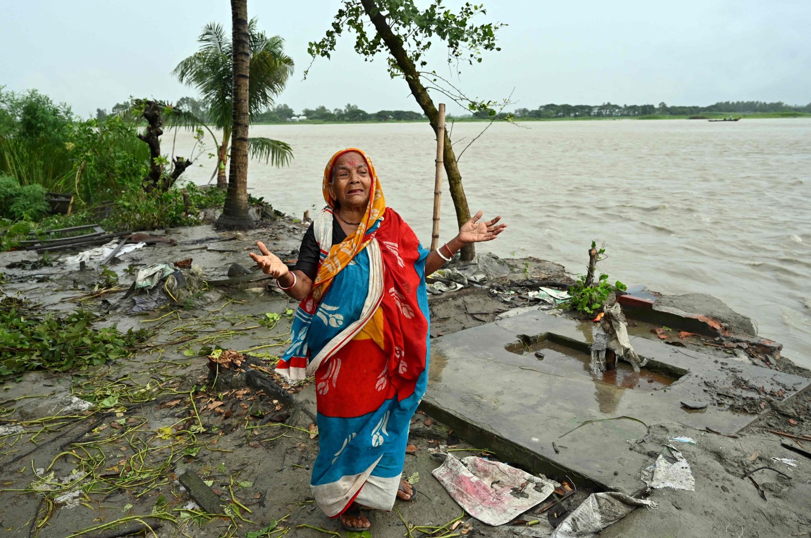 A resident mourns as she stands next to her eroded house on the banks of river Padma in Munshiganj, Bangladesh, Sept. 13, 2022. (AFP Photo)