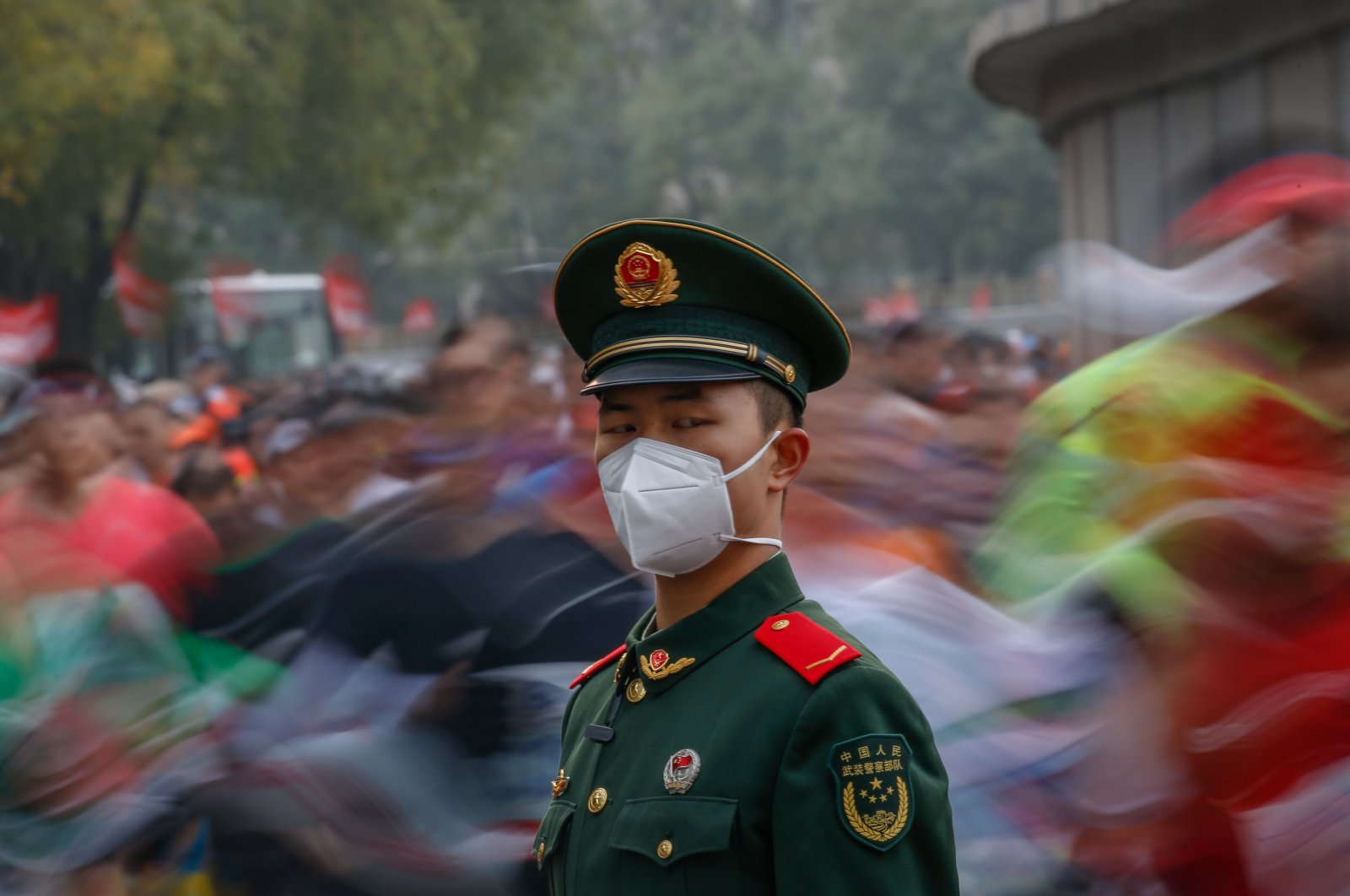 A soldier stands guard as runners compete during the Beijing Marathon in Beijing, China, Nov. 6, 2022. (EPA Photo)