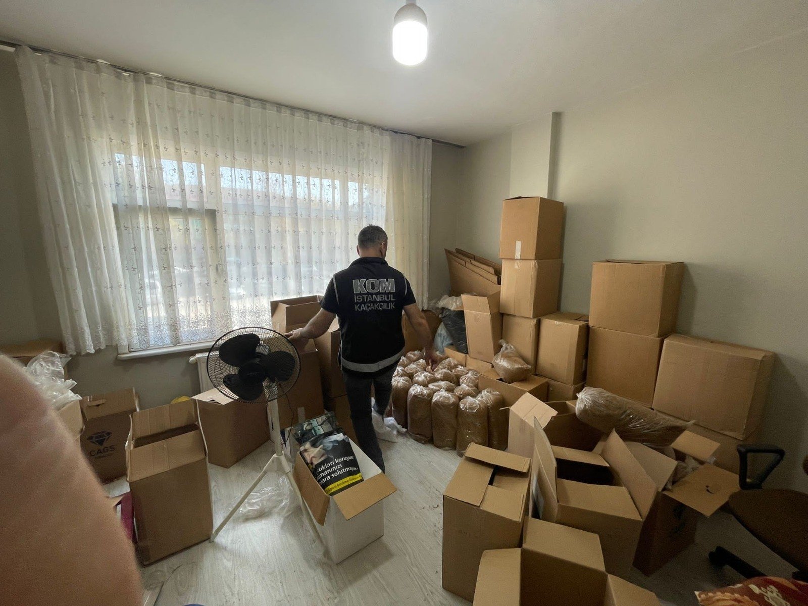 A police officer checks seized illicit tobacco in an apartment in Istanbul, Türkiye, Nov. 1, 2022. (İHA Photo)