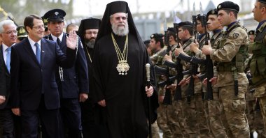 Orthodox Christian church Archbishop Chrysostomos II (C) with Cyprus' President Nicos Anastasiades (L) review the guard of honor, Nicosia, Cyprus, April 1, 2013. (AP Photo)